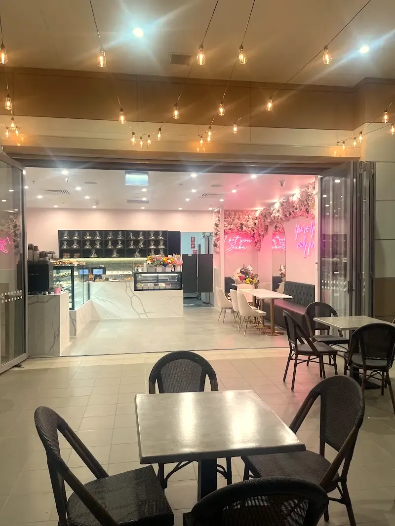 The cafe from Fairfield West Plaza: string lights, tables out front, the counter and the neon signs inside