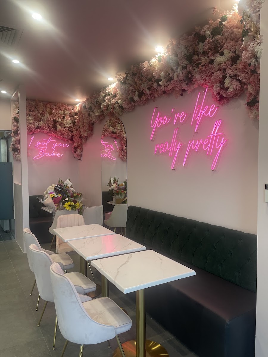 Inside The Sweetest Spot: the pink flower wall, the 'You're like really pretty' neon sign, marble tables and the teal velvet bench
